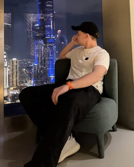 Ksawery Kamiński w fotelu przy oknie z widokiem na Burj Khalifa